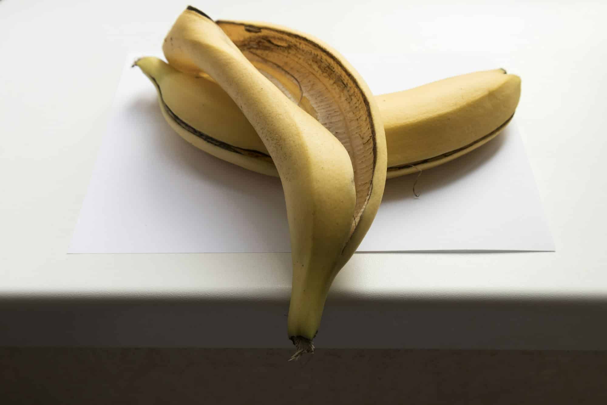 Banana skin on a white windowsill. Isolated over white background. Close-up.