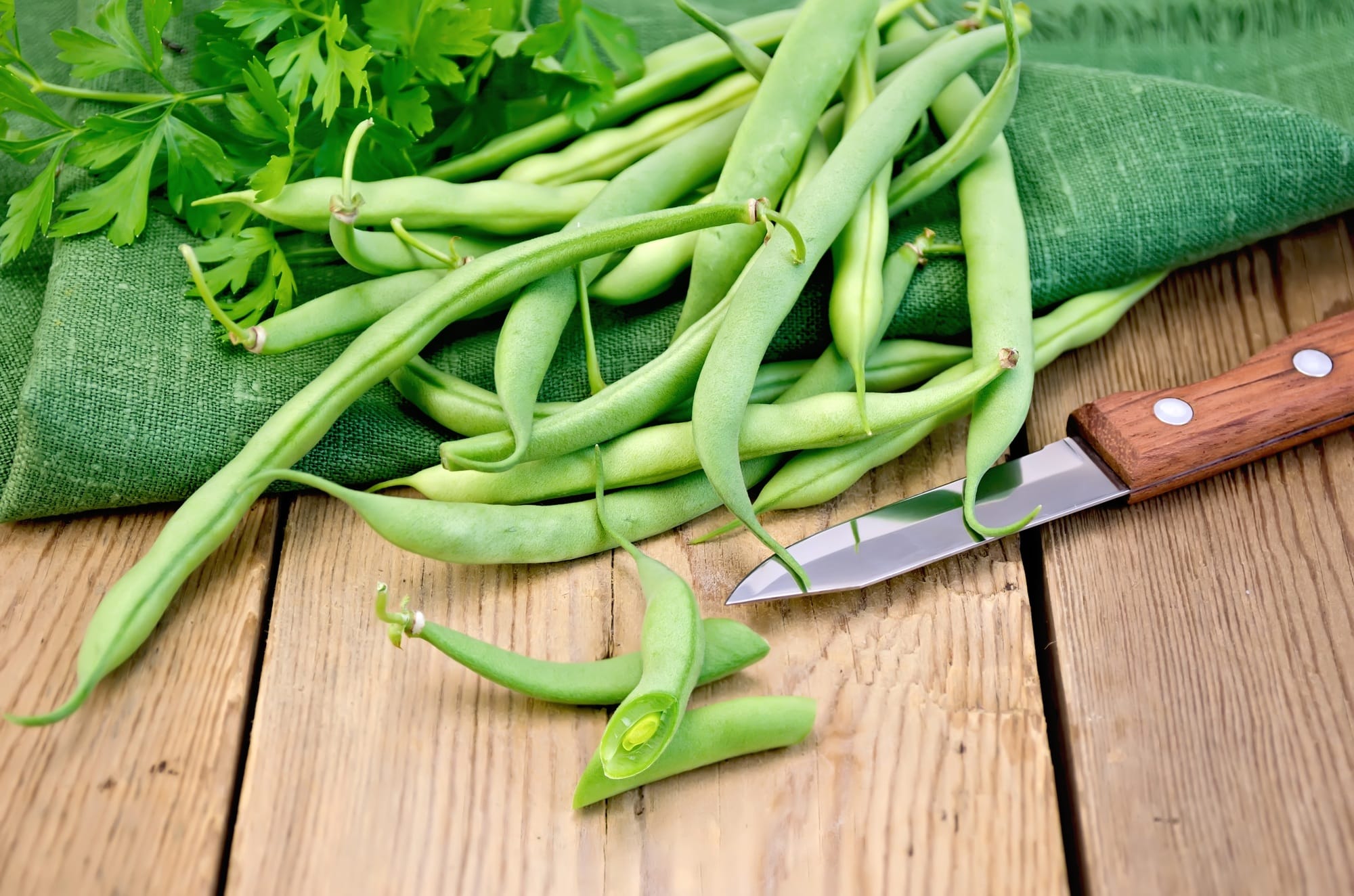 Beans green on the board with a knife